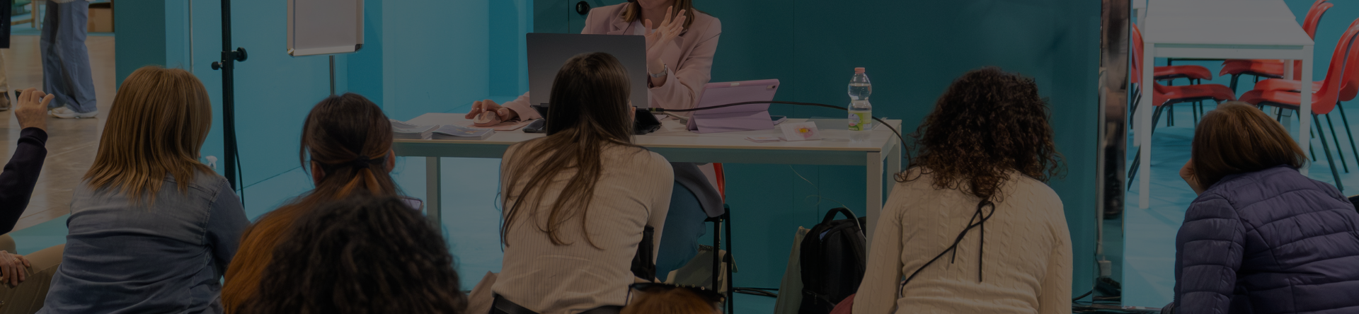 Relatrice durante un incontro formativo nell'area Edu Lab di Abilmente con partecipanti seduti ad assistere alla presentazione