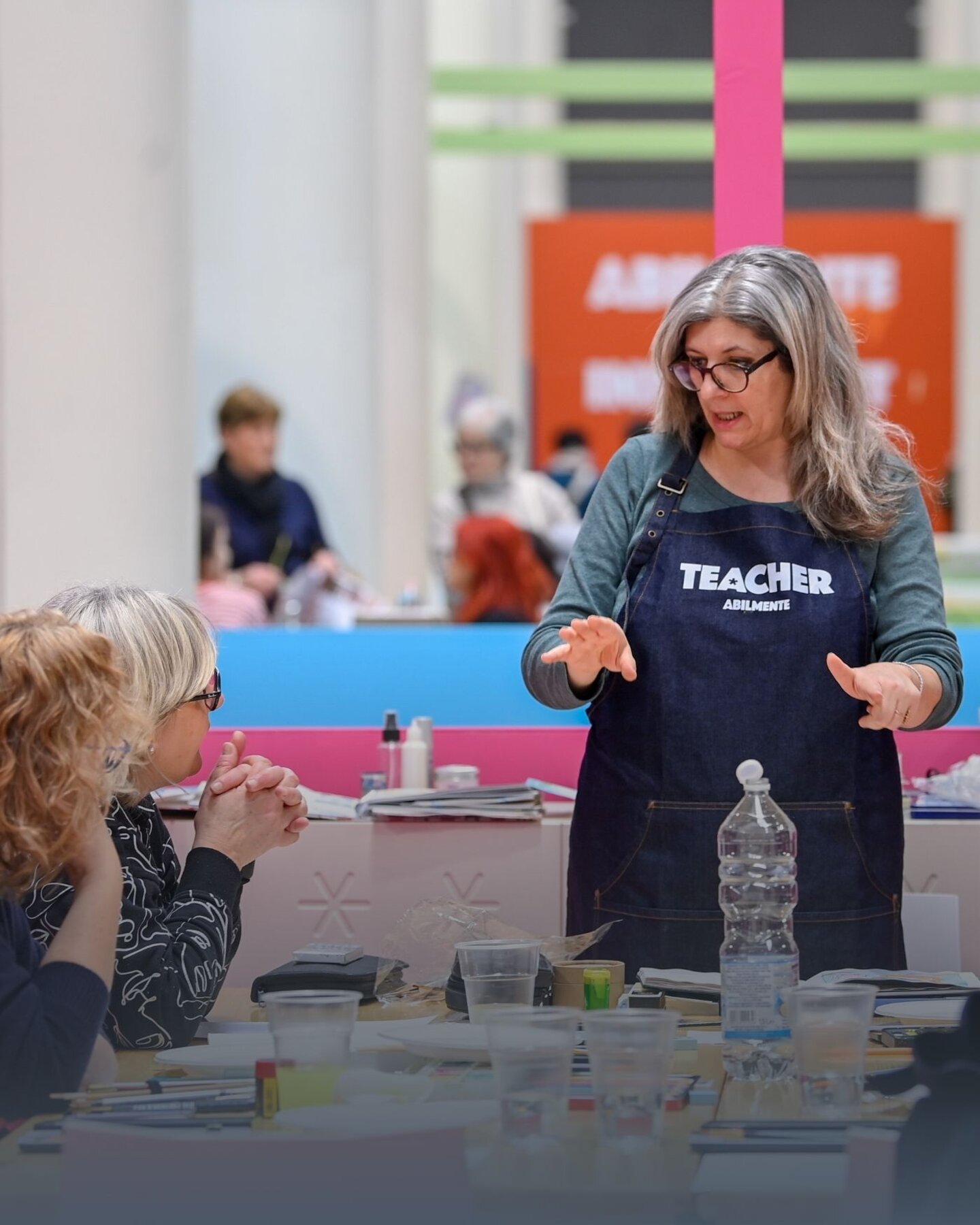 Laboratorio pratico di Edu Lab ad Abilmente Vicenza con un’insegnante che guida un gruppo di educatori tra materiali, tecniche artistiche e momenti di confronto creativo