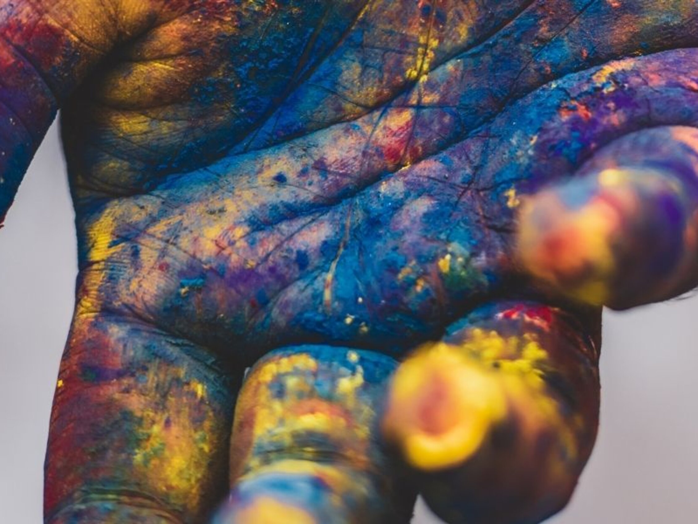 Mano dipinta con colori vivaci, simbolo di creatività e inclusione sociale durante il seminario Autòs ad Abilmente Vicenza 2025.