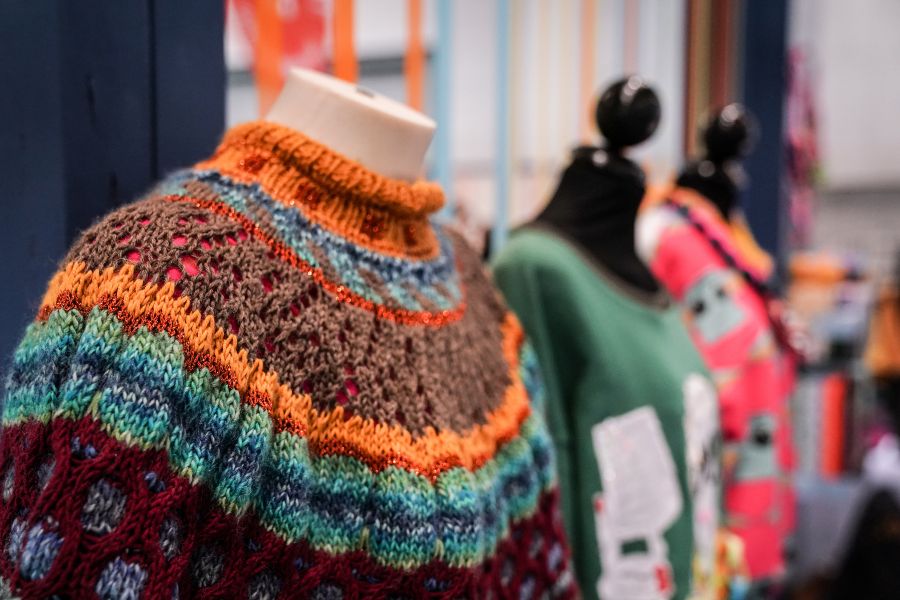 maglione colorato fatto a mano su manichino